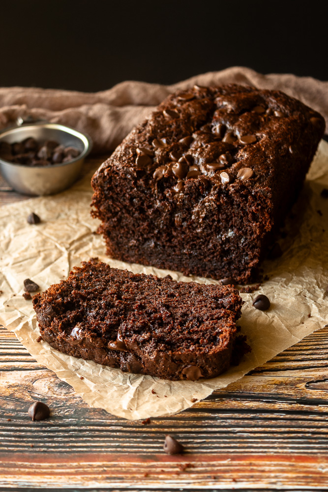 Angled shot of Double chocolate zucchini bread with a slice in front.