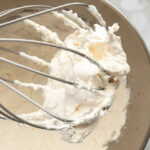 Healthier whipped cream in bowl with whisk overhead shot.