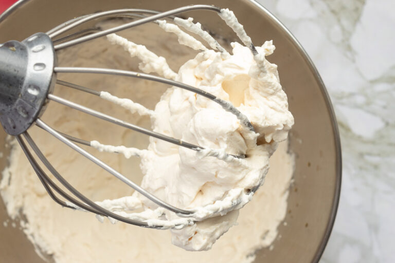 Healthier whipped cream in bowl with whisk overhead shot.