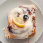 Overhead shot of Lemon Blueberry Sweet Roll on plate with cream cheese frosting.